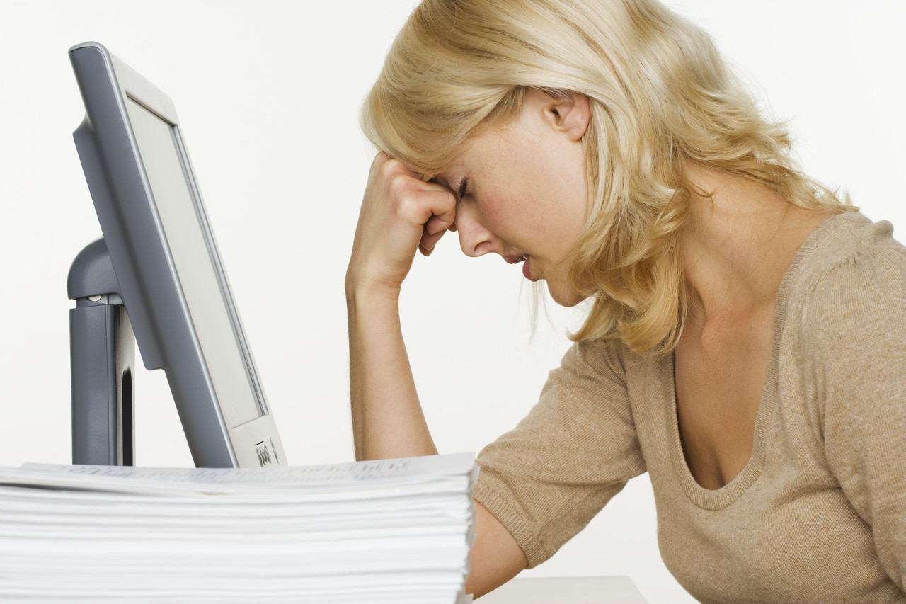 Frustrated Woman at Computer With Stack of Paper